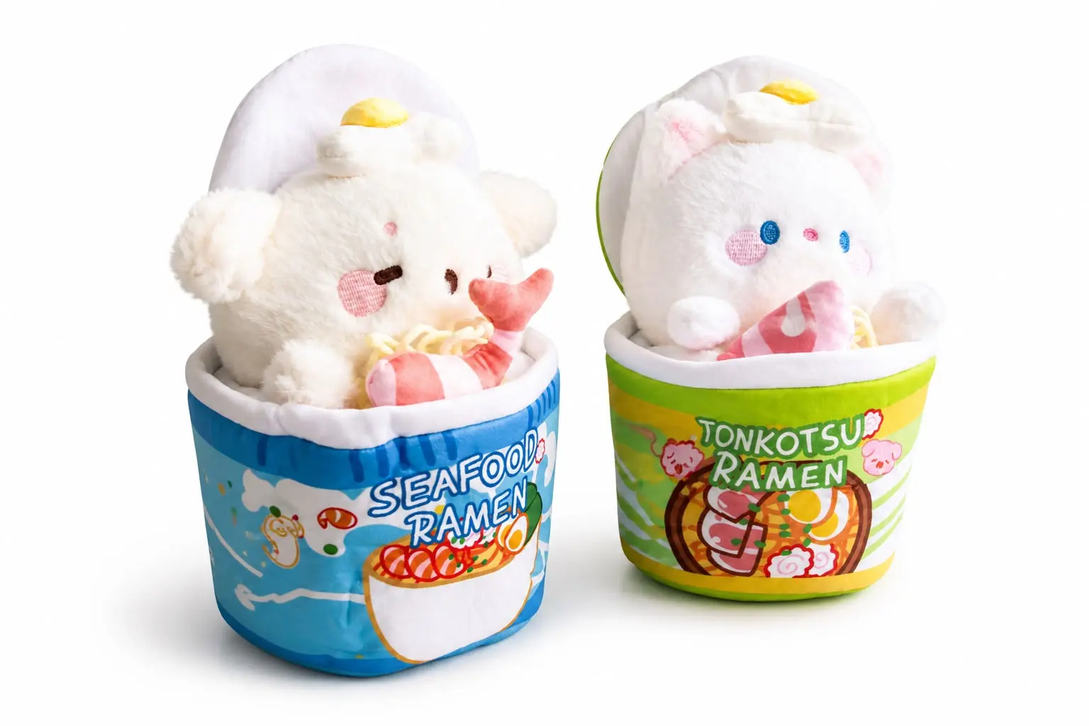 Dos peluches de ramen kawaii con forma de taza, uno azul de mariscos y otro verde de tonkotsu, ambos con personajes blancos y huevo decorativo encima.