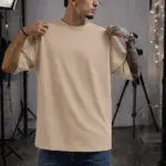 Camiseta oversize de algodón color beige en estudio, corte amplio y cuello redondo, uso casual.