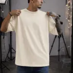 Hombre con camiseta oversize de algodón color marfil, corte holgado, manga corta y cuello redondo en estudio.