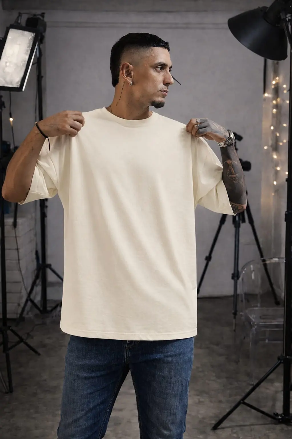 Hombre con camiseta oversize de algodón color marfil, corte holgado, manga corta y cuello redondo en estudio.