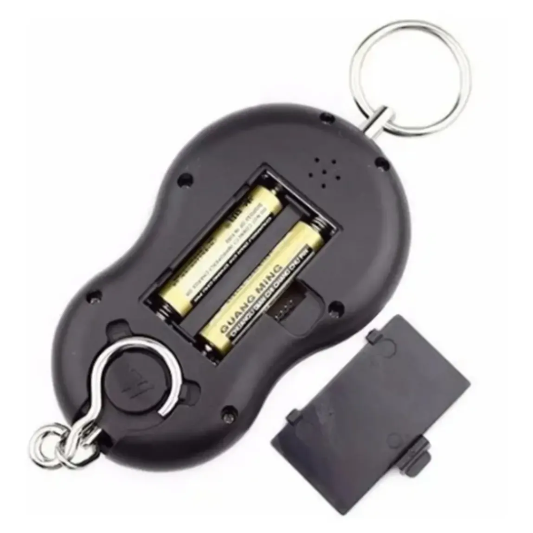 Báscula digital portátil negra para equipaje con tapa de compartimento de baterías abierta, mostrando dos pilas amarillas y gancho metálico inferior.