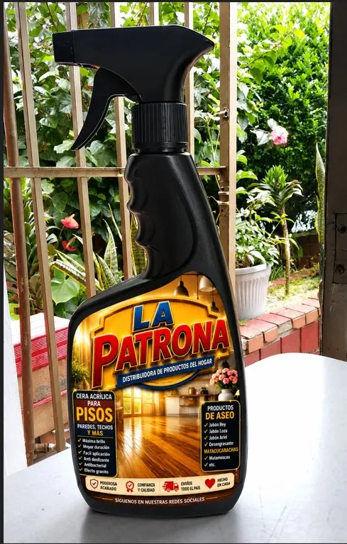 Botella spray negra de 500 ml con atomizador y etiqueta dorada de limpiador multiusos para pisos, colocada sobre una mesa blanca frente a una ventana.