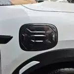 Protector de puerto de carga para BYD Yuan UP con acabado en fibra de carbono, diseño texturizado de alta resistencia instalado en el lateral del vehículo.