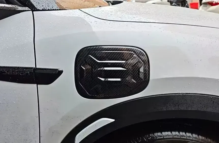Protector de puerto de carga para BYD Yuan UP con acabado en fibra de carbono, diseño texturizado de alta resistencia instalado en el lateral del vehículo.