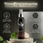 Tónico capilar en frasco oscuro con atomizador sobre base de mármol, rodeado de ginkgo y cebolla. Fórmula con 8% de trichogen para frenar la caída.