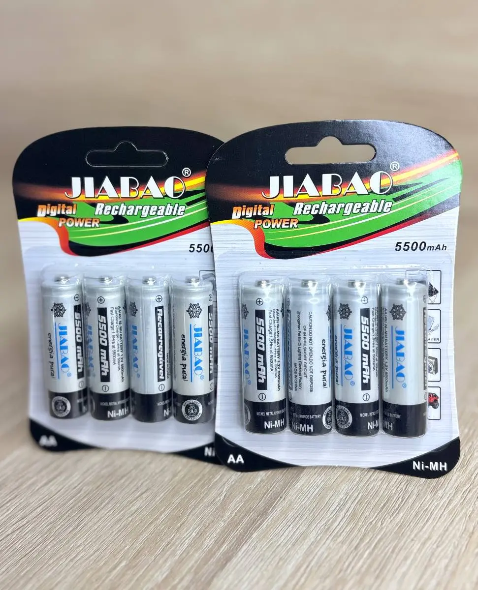 Dos empaques de cartón con plástico transparente que muestran pilas recargables AA Ni-MH plateadas y negras de 5500 mAh sobre superficie de madera