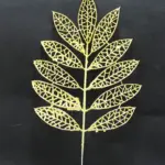 Pin floral navideño dorado con hojas brillantes en forma de gota y patrón de red, ideal para decorar árboles y coronas festivas.
