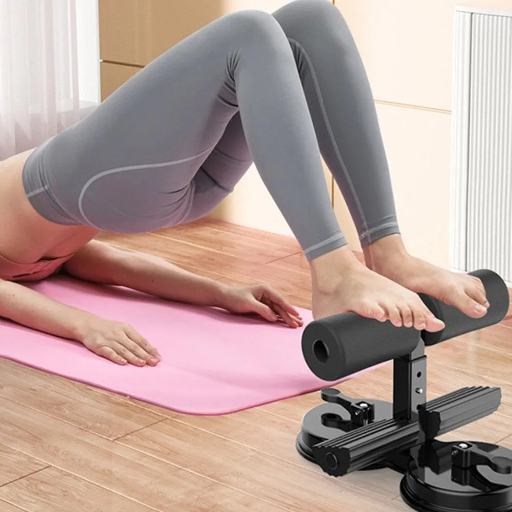 Soporte negro con rodillos de espuma y doble ventosa, usado por mujer en esterilla rosa haciendo puente de glúteos en piso de madera.