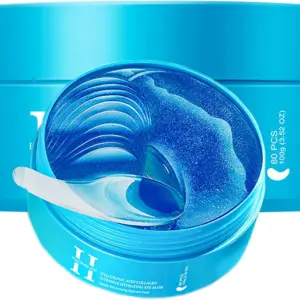 Dos tarros azules con mascarillas de hidrogel para ojos dispuestas en capas, acompañadas por una espátula transparente.