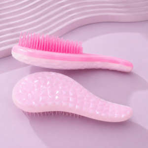 Dos cepillos para definir rizos en tonos rosa con mango texturizado y cerdas de color rosa intenso, mostrados en vista lateral y posterior.