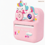 Cámara infantil rosa con diseño de unicornio colorido, ranura de impresión instantánea y detalles decorativos de nubes y corazones.