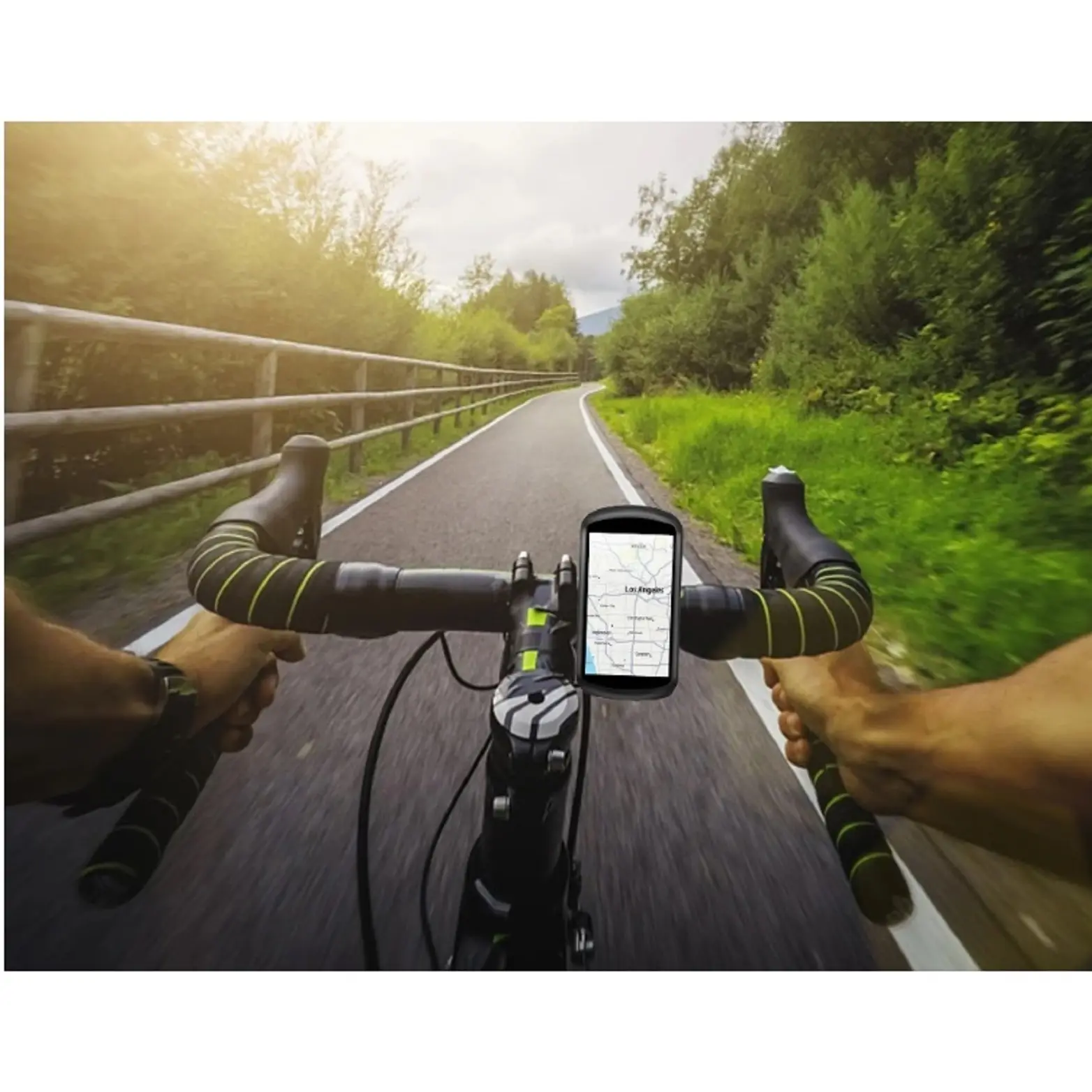 Funda protectora roja para GPS de ciclismo instalada en el manubrio de una bicicleta, mostrando un mapa en pantalla mientras recorre un camino arbolado.