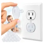Set de 10 protectores de enchufe transparentes de plástico, mostrados en uso sobre una toma de pared blanca junto a un bebé y una pila de unidades.
