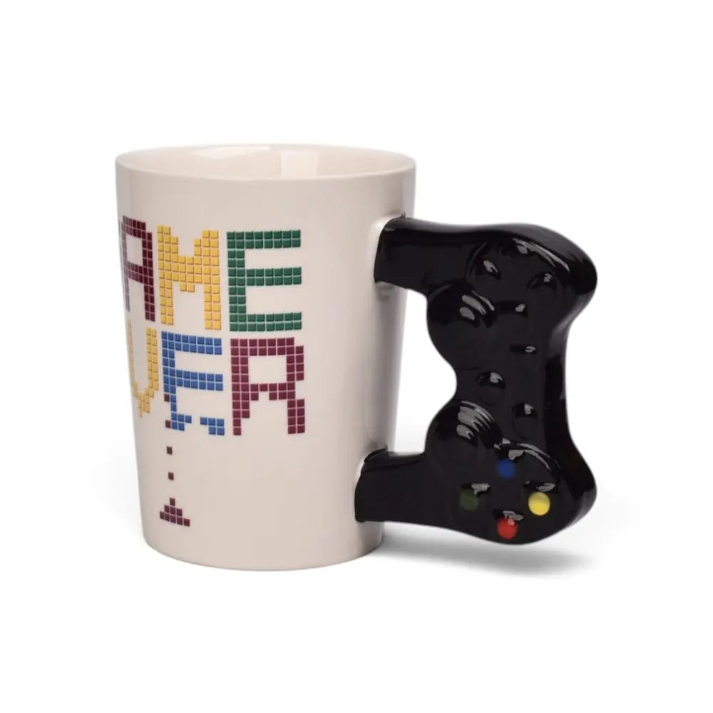 Taza de cerámica blanca con diseño pixelado de Game Over y asa moldeada en forma de control de videojuegos negro con botones coloridos.