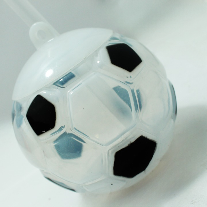 Termo infantil con pitillo y tapa blanca superior, diseño esférico transparente con patrón en relieve de balón de fútbol y pentágonos negros.
