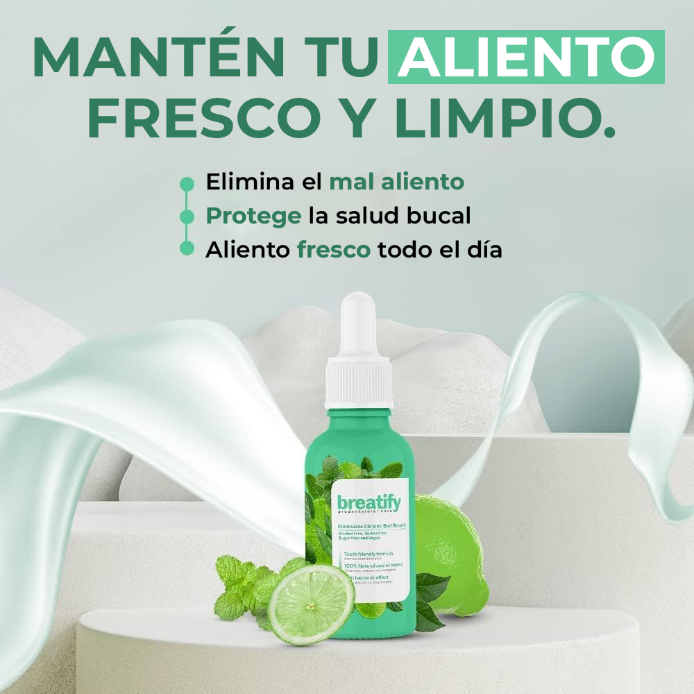 Frasco verde de suero bucal con gotero blanco, rodeado de limones y hojas de menta sobre pedestal, para eliminar el mal aliento y proteger la salud bucal.