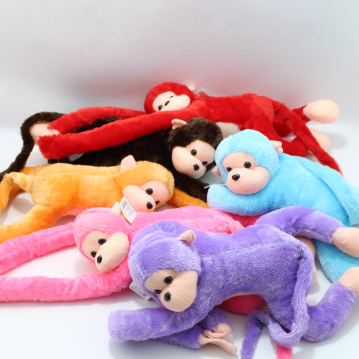 Peluche de mono suave con extremidades flexibles en colores rojo, café, anaranjado, azul, rosado y morado para decorar habitaciones y jugar.
