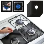 Set de cuatro protectores negros antiadherentes para estufa de gas, mostrados en uso sobre una cocina blanca y en detalle de instalación sobre los quemadores.