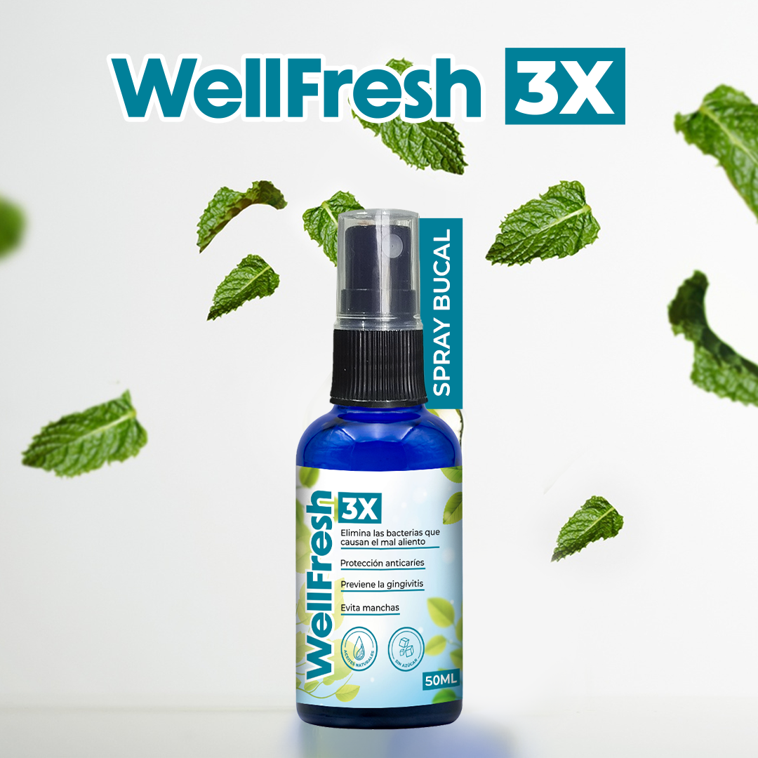 Spray bucal antiséptico WellFresh 3X de 50 ml en botella azul con atomizador negro, rodeado por hojas de menta sobre fondo blanco.