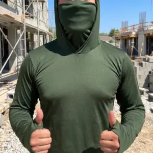 Hombre de frente en obra gris usa buzo licrado verde con capucha y tapabocas integrado, mangas largas con ojal para pulgar.