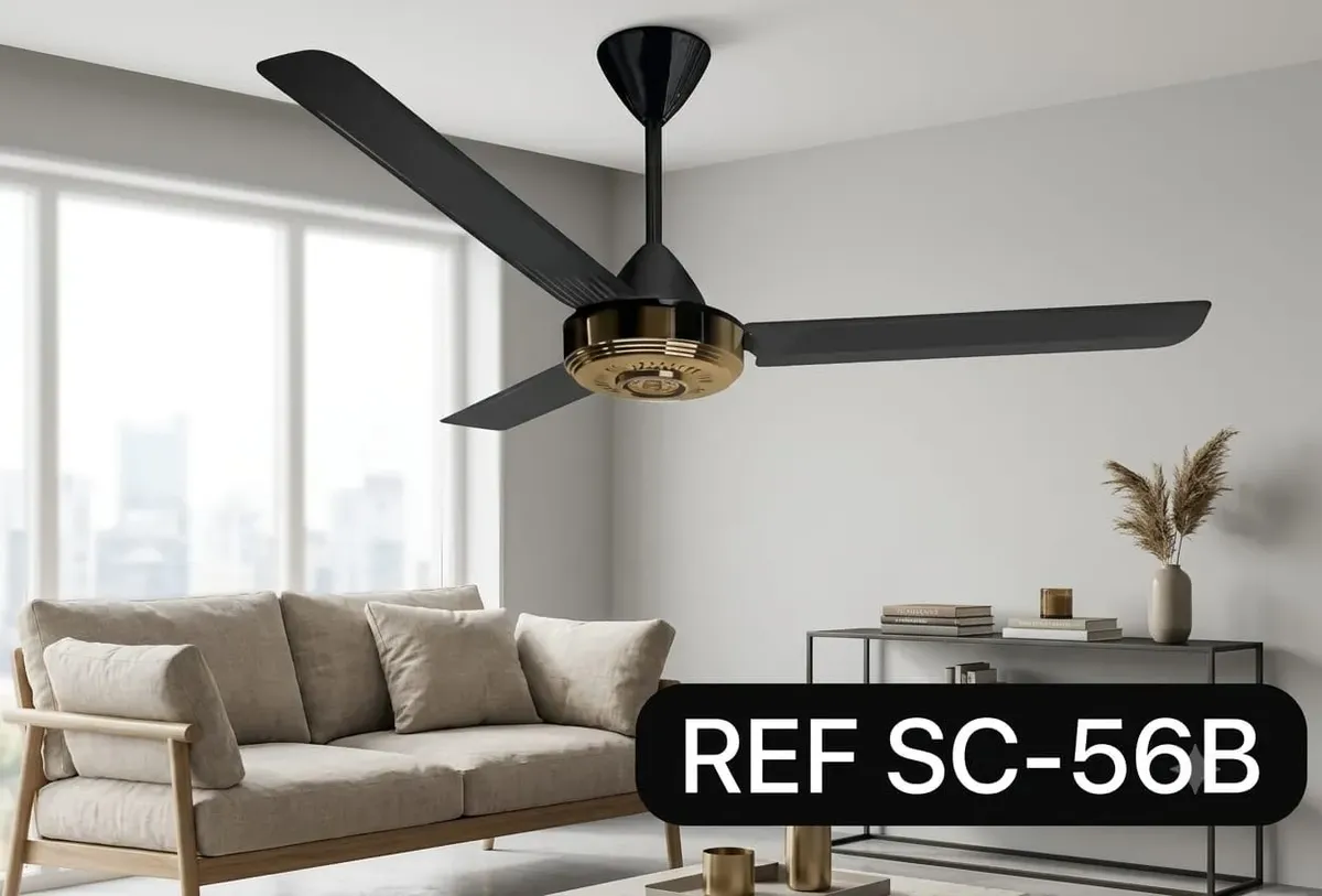 Ventilador de techo negro de tres aspas con centro metálico dorado, modelo SC-56B, en una sala moderna y luminosa.