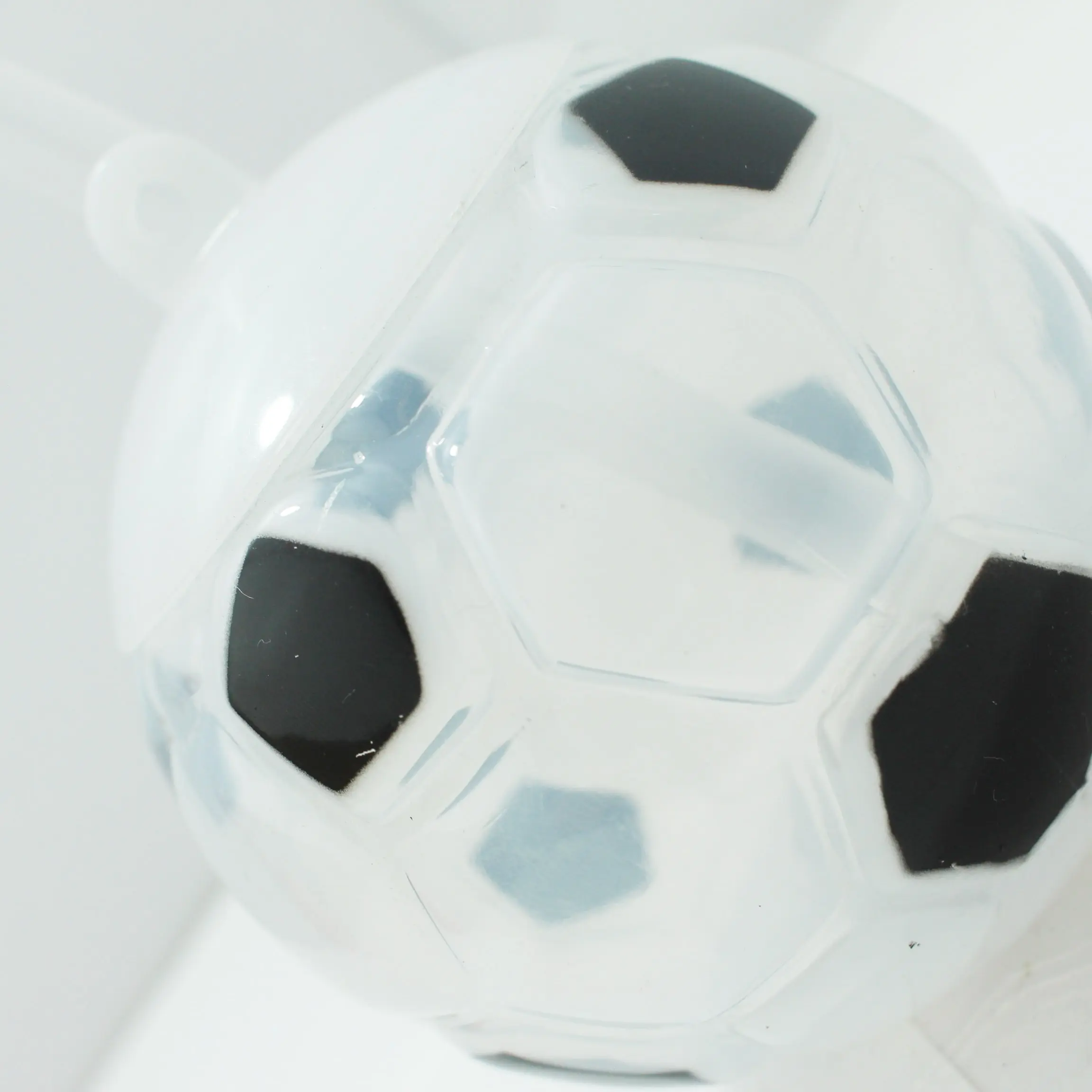 Termo infantil con pitillo, diseño esférico en blanco y negro simulando un balón de fútbol con textura plástica semitransparente.
