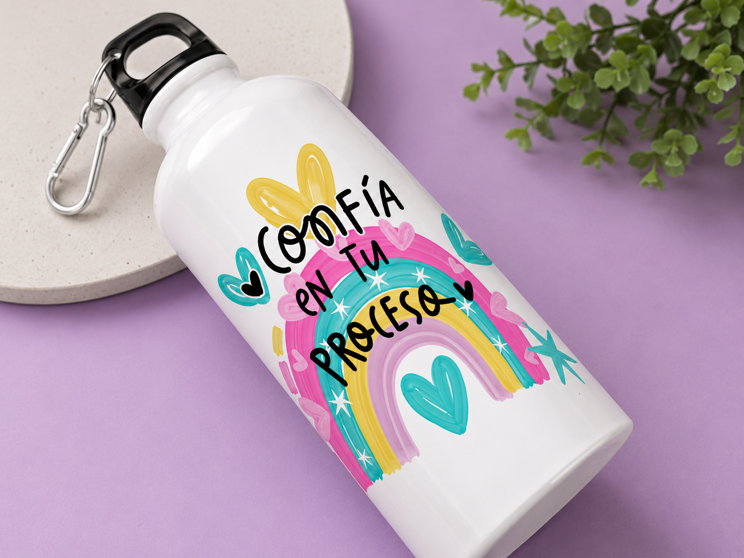 Termo metálico blanco con diseño de arcoíris y corazones en tonos pastel, frase inspiradora en negro, mosquetón negro y fondo morado.