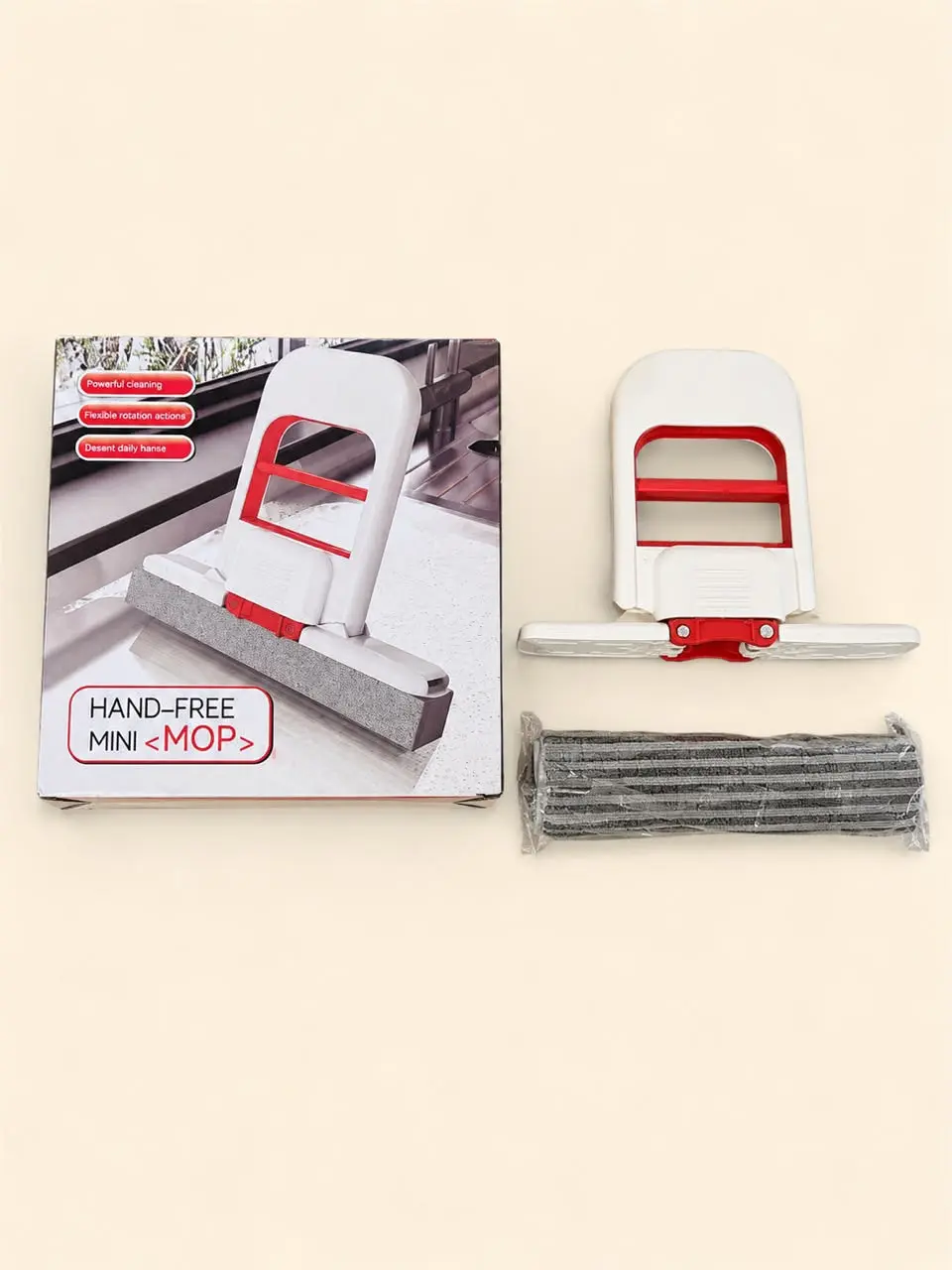 Mini mopa escurridora manual blanca y roja con esponja gris, incluye caja de empaque y un repuesto de esponja adicional sellado en plástico transparente.