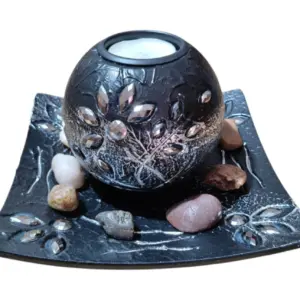 Centro de mesa decorativo de resina negra con detalles plateados, portavelas esférico y base con piedras naturales de colores.