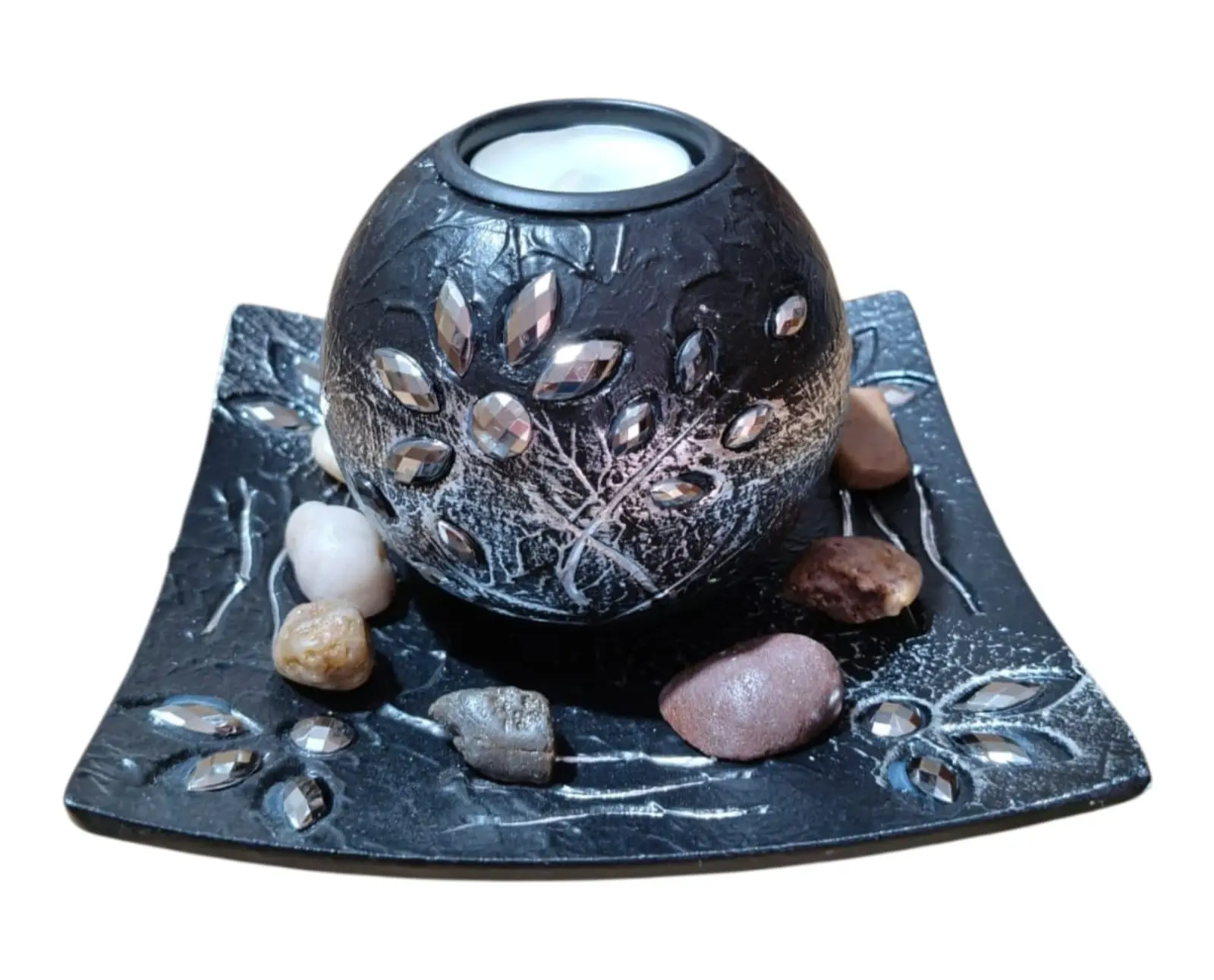 Centro de mesa decorativo de resina negra con detalles plateados, portavelas esférico y base con piedras naturales de colores.