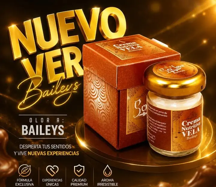 Vela hidratante para masaje con aroma a Baileys, en frasco con tapa dorada y caja naranja decorativa sobre un pedestal brillante y elegante.