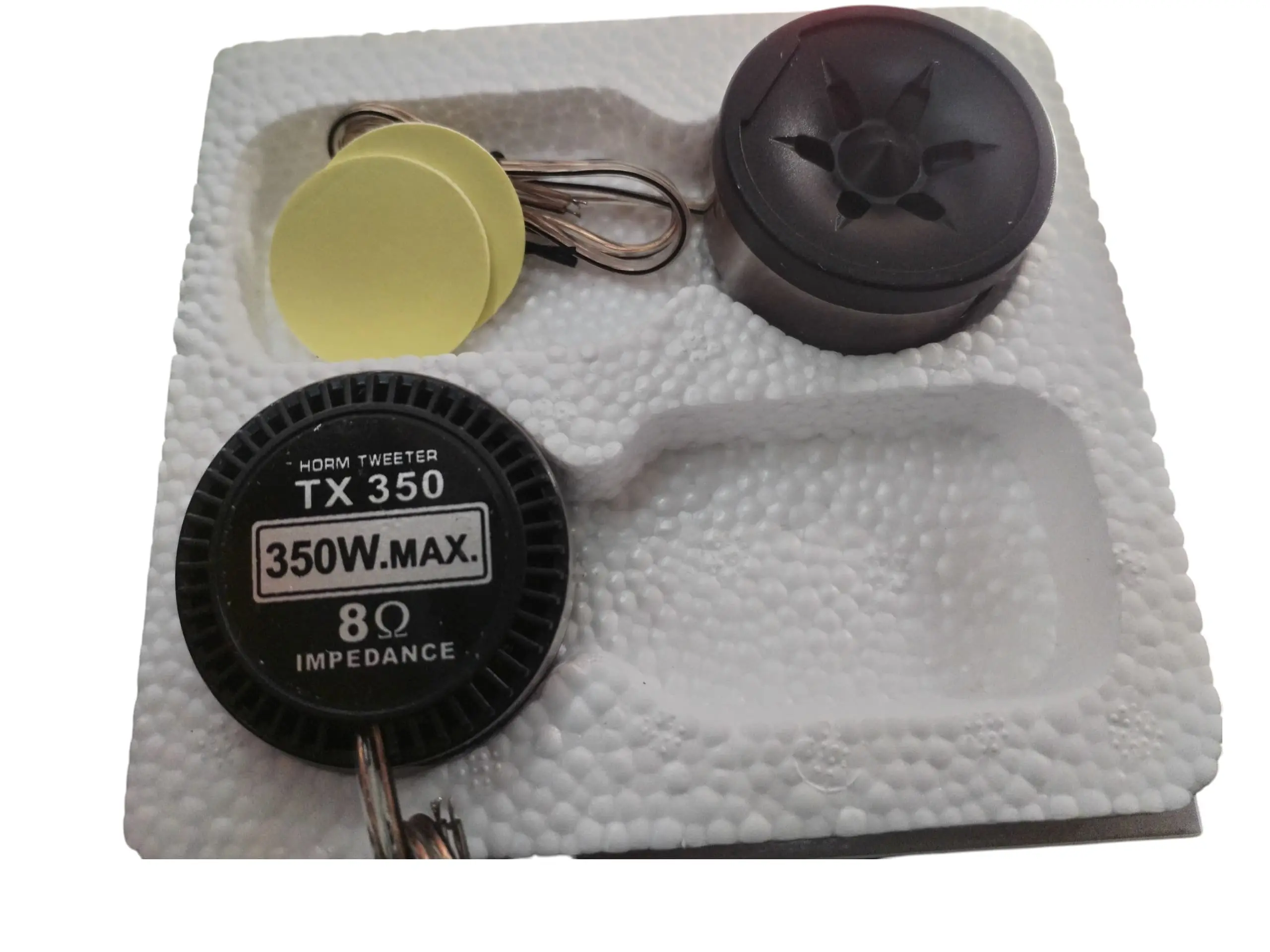 Par de tweeters para carro TX 350 de 350W y 8 Ohm, incluye dos adhesivos circulares y cables de conexión en empaque de poliestireno expandido blanco.