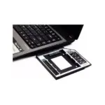 Caddy adaptador de disco duro HDD o SSD negro y plateado junto a una laptop abierta para expandir el almacenamiento interno del equipo.