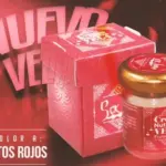 Crema nutritiva de frutos rojos para masaje en frasco de vidrio con tapa dorada y caja roja decorativa sobre fondo rojo.