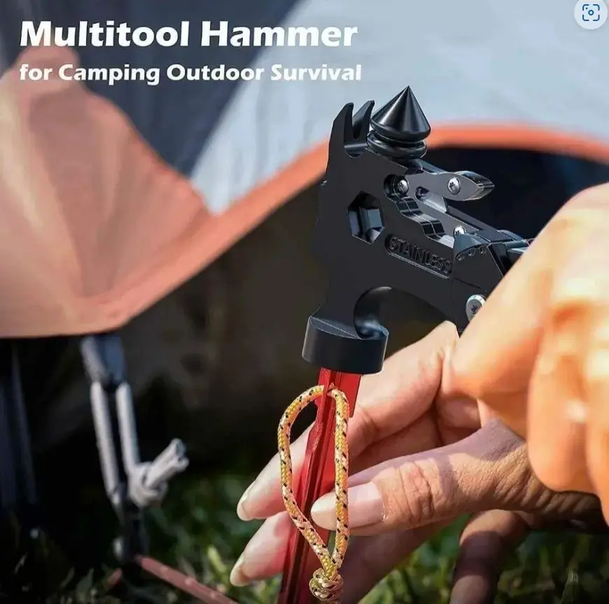 Martillo multiherramientas negro de acero inoxidable usado para extraer una estaca roja de camping en el césped.