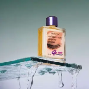 Frasco de 15 ml de aceite para pestañas Prosa con tapa morada, posado sobre una superficie de vidrio transparente con gotas de agua cayendo.