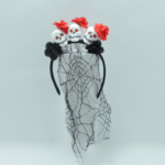 Diadema gótica negra con tres calaveras blancas de ojos rojos, flores rojas, flores negras y un velo traslúcido con telaraña.