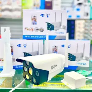 Cámara de seguridad exterior IP66 blanca con dos antenas, lentes múltiples de visión nocturna, soporte de pared y fuente de alimentación sobre fondo de cajas.