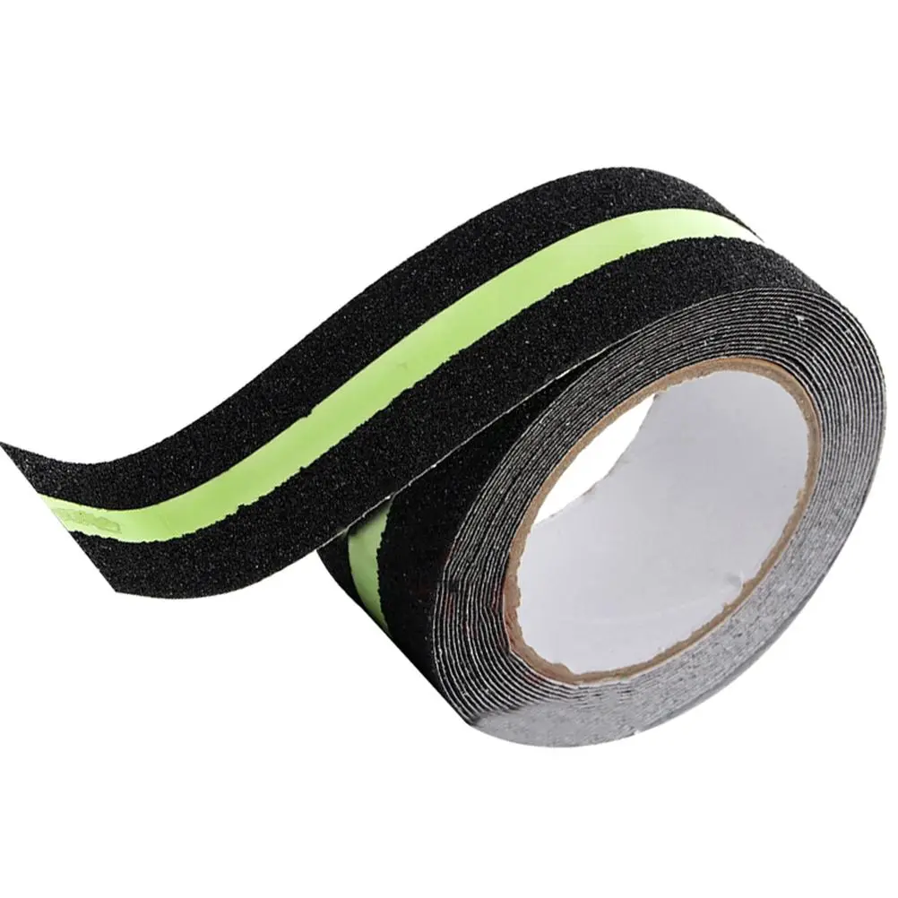 Rollo de cinta antideslizante negra con franja verde neón, textura granulada para seguridad en escaleras y señalización de rutas de evacuación.