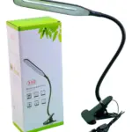 Lámpara de escritorio LED negra con pinza y brazo flexible, junto a su caja de empaque con diseño verde y blanco.